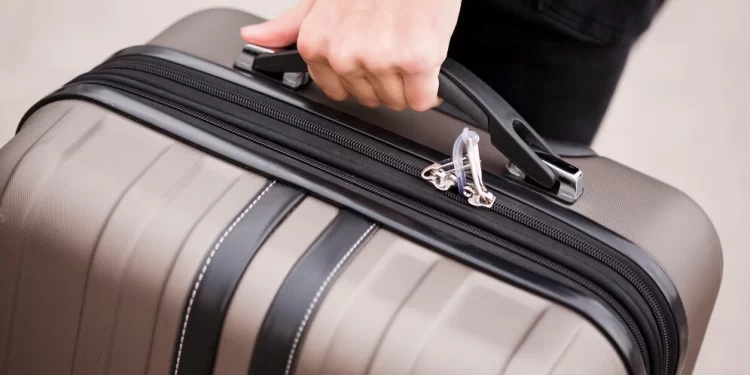 close-up-hand-holding-luggage_23-2148357279