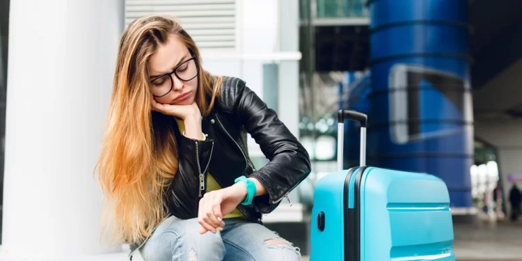 portrait-pretty-girl-with-long-hair-glasses-sitting-outside-airport-she-wears-yellow-sweater-with-black-jacket-jeans-she-leaned-suitcase-is-looking-bored-watch_197531-457